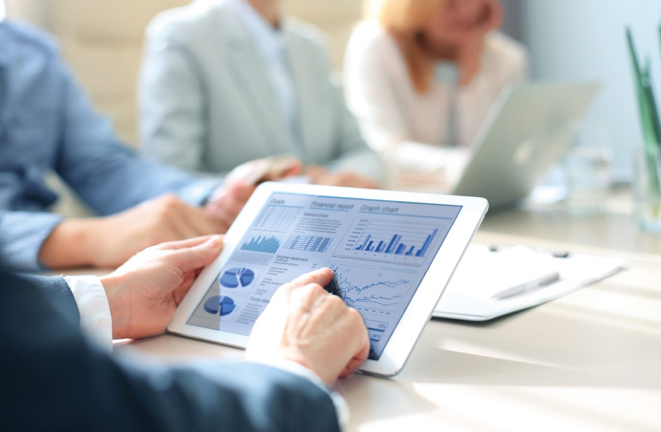 Business person analyzing financial statistics displayed on the tablet screen.